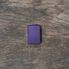 Lifestyle image of Purple Matte windproof lighter laying flat on a wooden surface