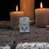 Lifestyle image of Anne Stokes Wolf Pack Lighter standing on cobblestone with lit candles in the background