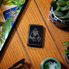 Lifestyle image of Bar Skull Design Windproof Lighter laying on a side stand