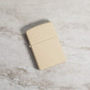 Lifestyle image of Classic Flat Sand Windproof Lighter laying on a marble surface
