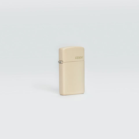 Lifestyle image of Slim® Flat Sand Zippo Logo Windproof Lighter standing in a grey scene.