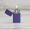 Lifestyle image of Slim® Purple Matte Windproof Lighter with its lid open and lit