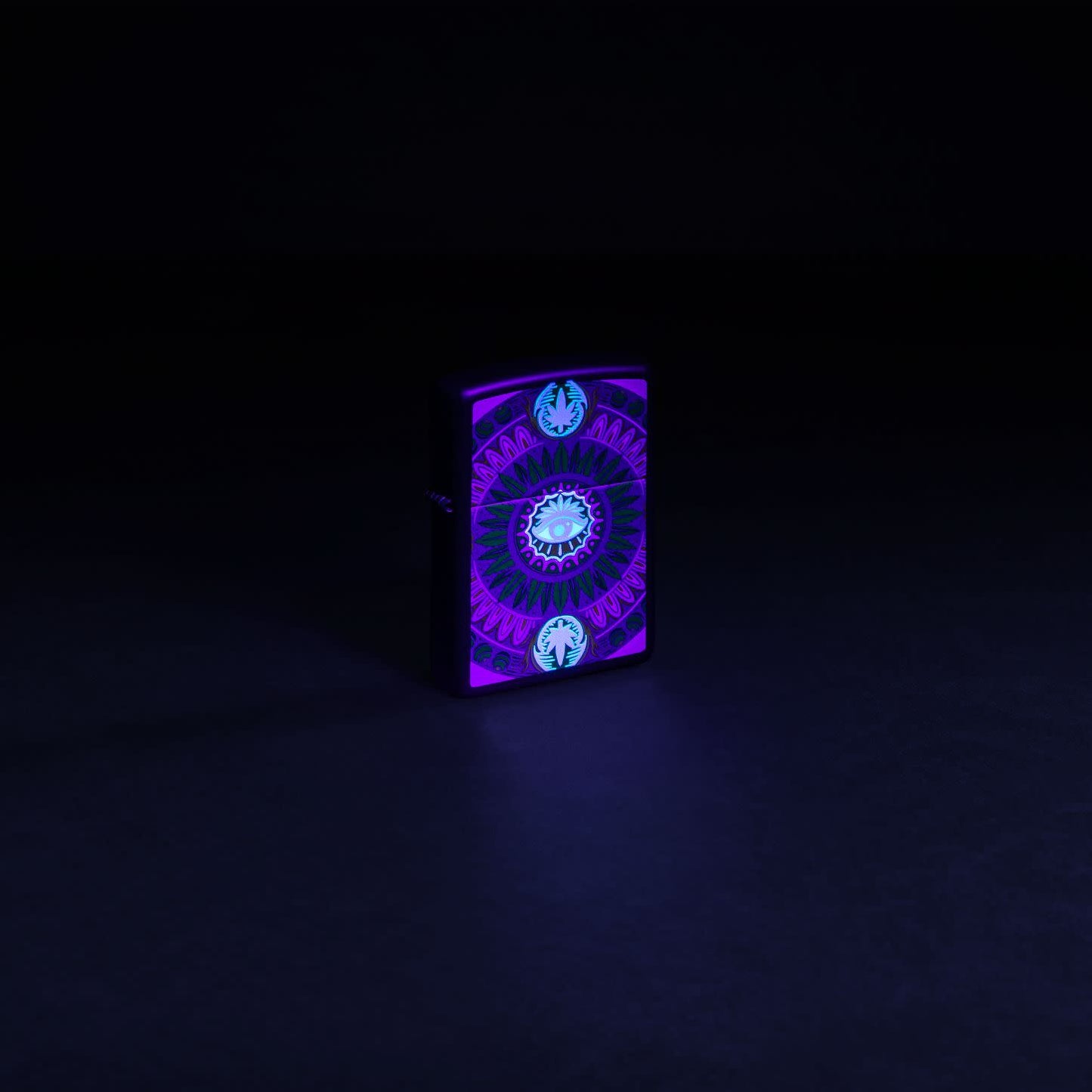 Glamour shot of Zippo Black Light Cannabis Pattern Design Black Matte Windproof Lighter glowing with a black light.