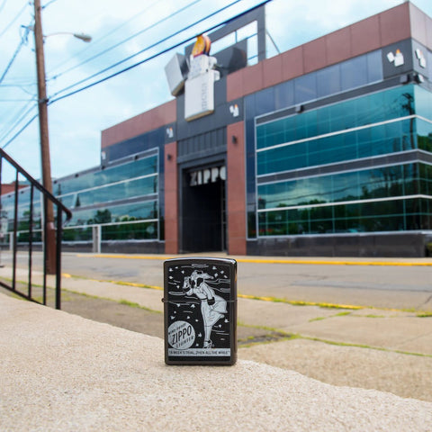 Lifestyle image of Windy Design High Polish Black Windproof Lighter standing in front of Zippo building.