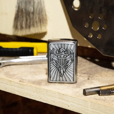 Lifestyle image of Eagle Shield Emblem Design Street Chrome™ Windproof Lighter standing on a workbench with tools.